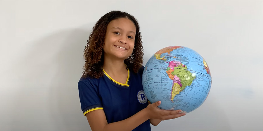 menina segurando um globo -  Intercâmbio e idade ideal: como decidir o melhor momento para estudar fora